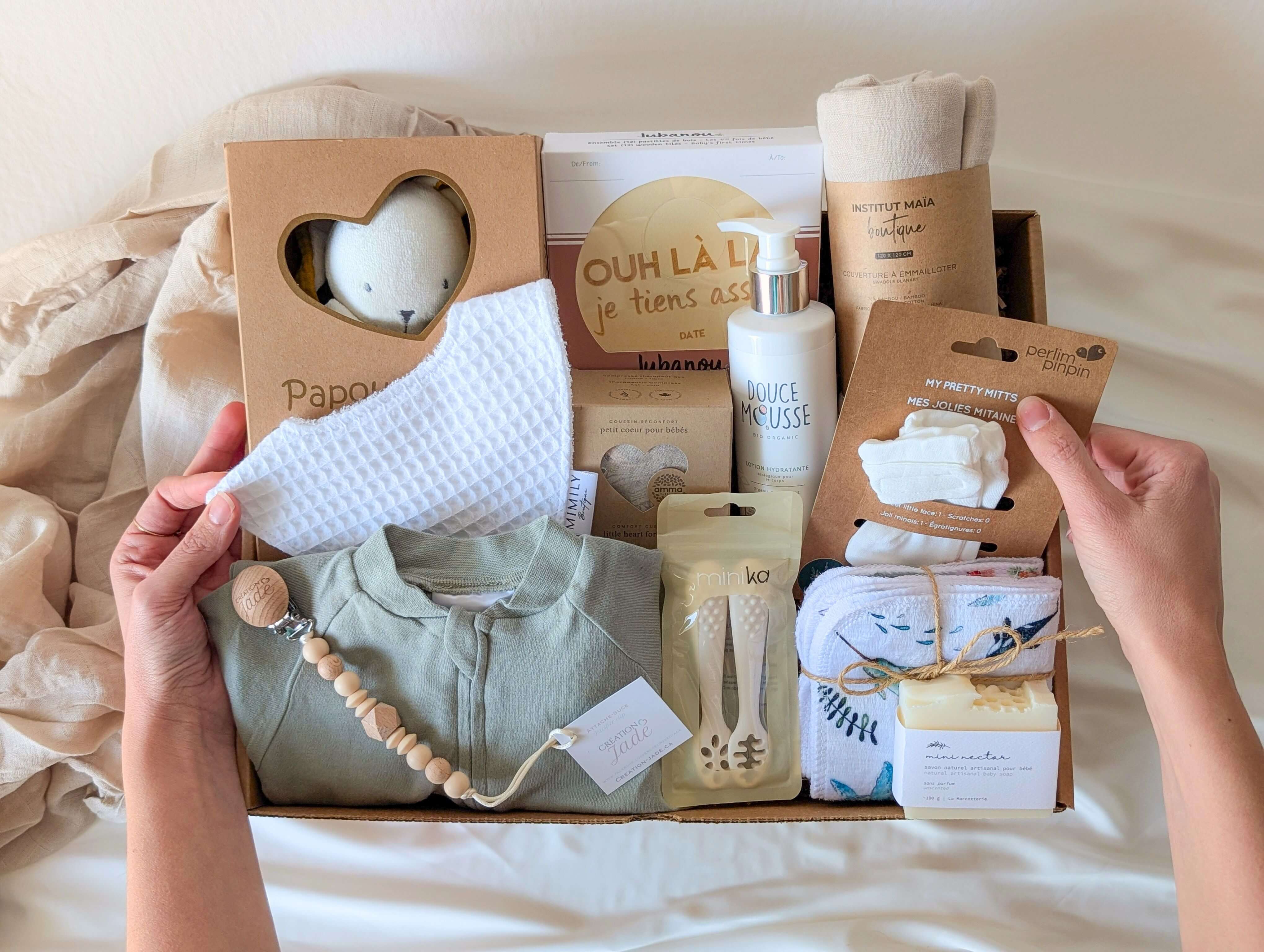 Boîte cadeau naissance bébé avec doudou, vêtements, soins doux et accessoires québécois