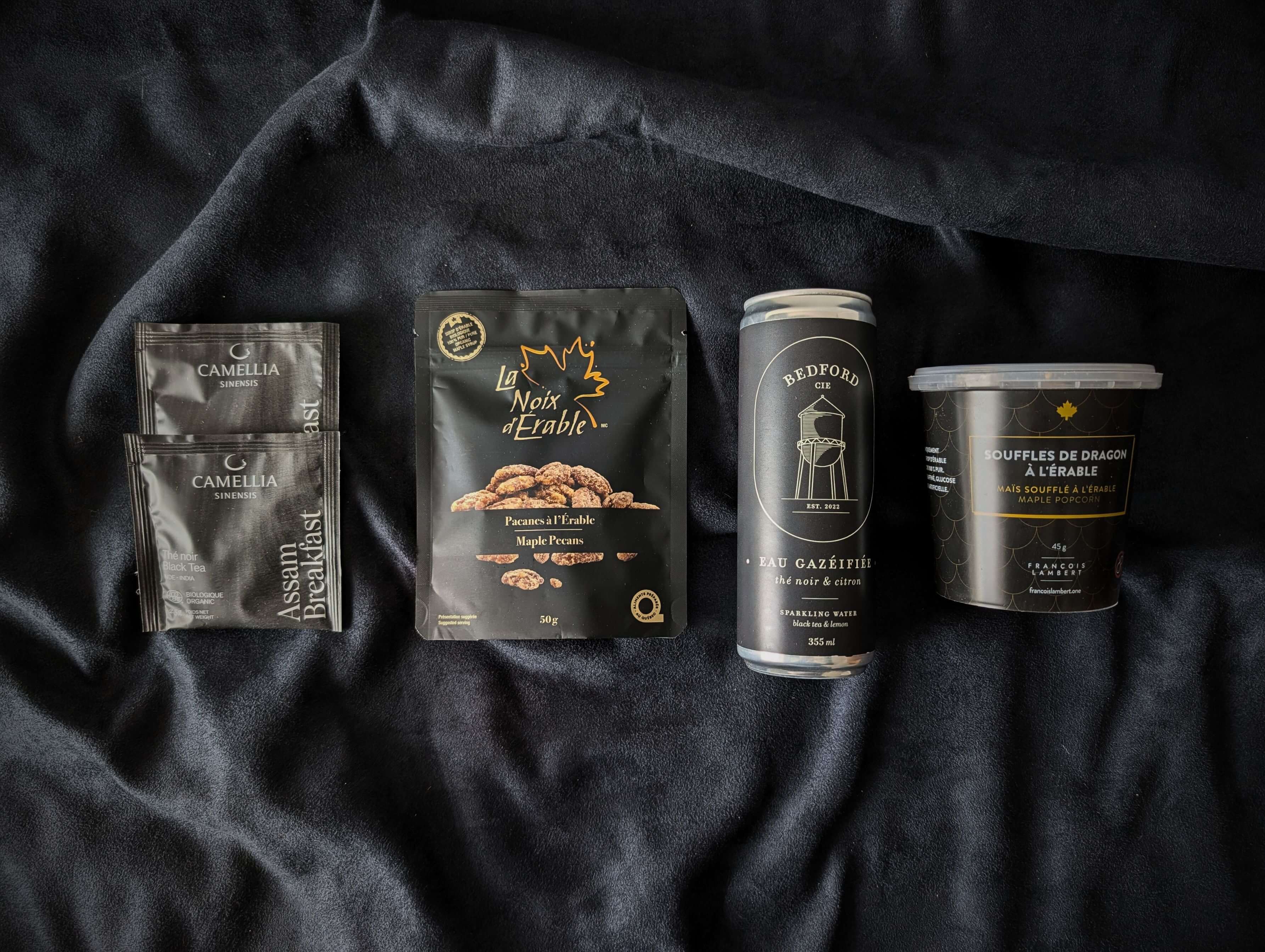 Produits québécois de la boîte Noir gourmand avec pacanes à l’érable, thé Assam et eau pétillante citron